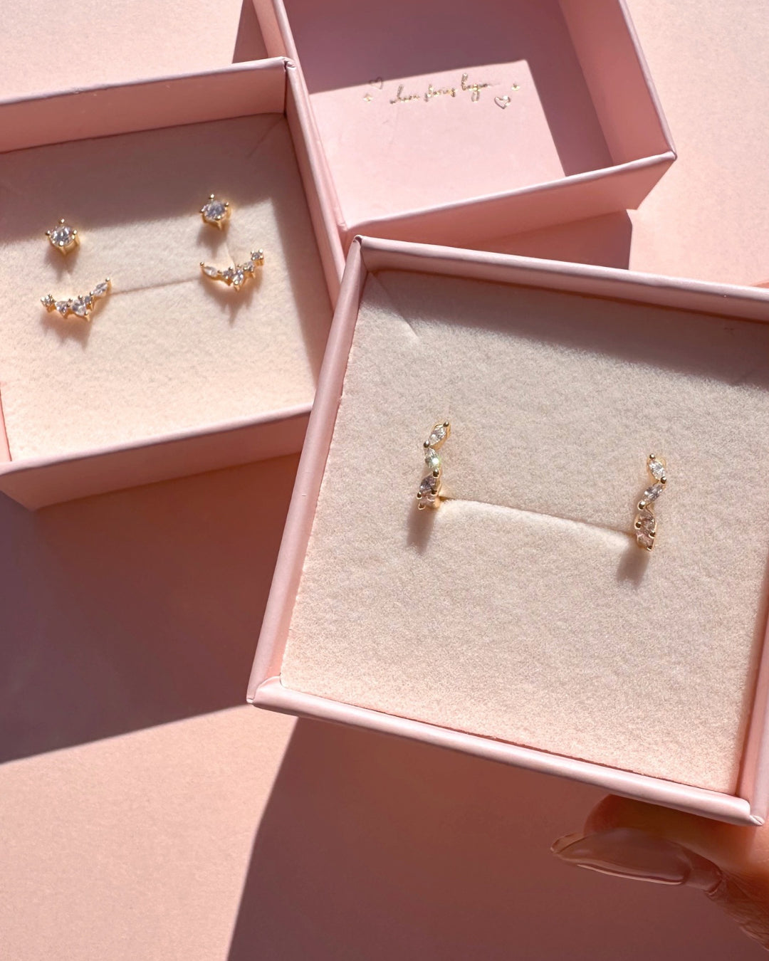 Gold vermeil huggie earrings with marquise cut crystals in a Romyli jewellery box