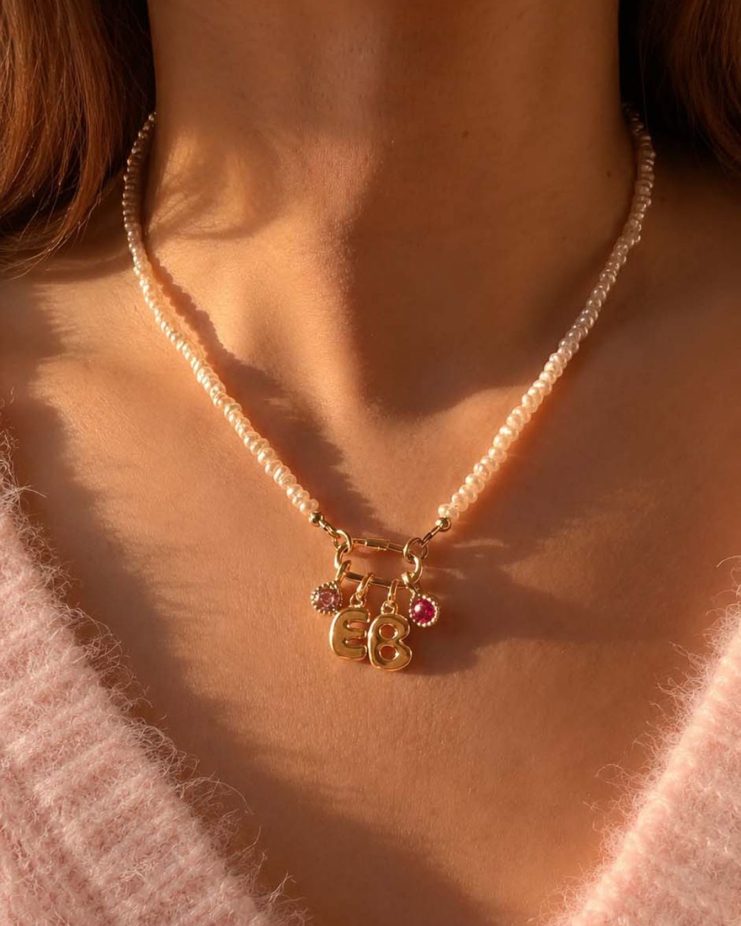 Pearl Charm Holder Necklace with a gold bubble initial pendant charm and pink tourmaline birthstone charms worn by a person.