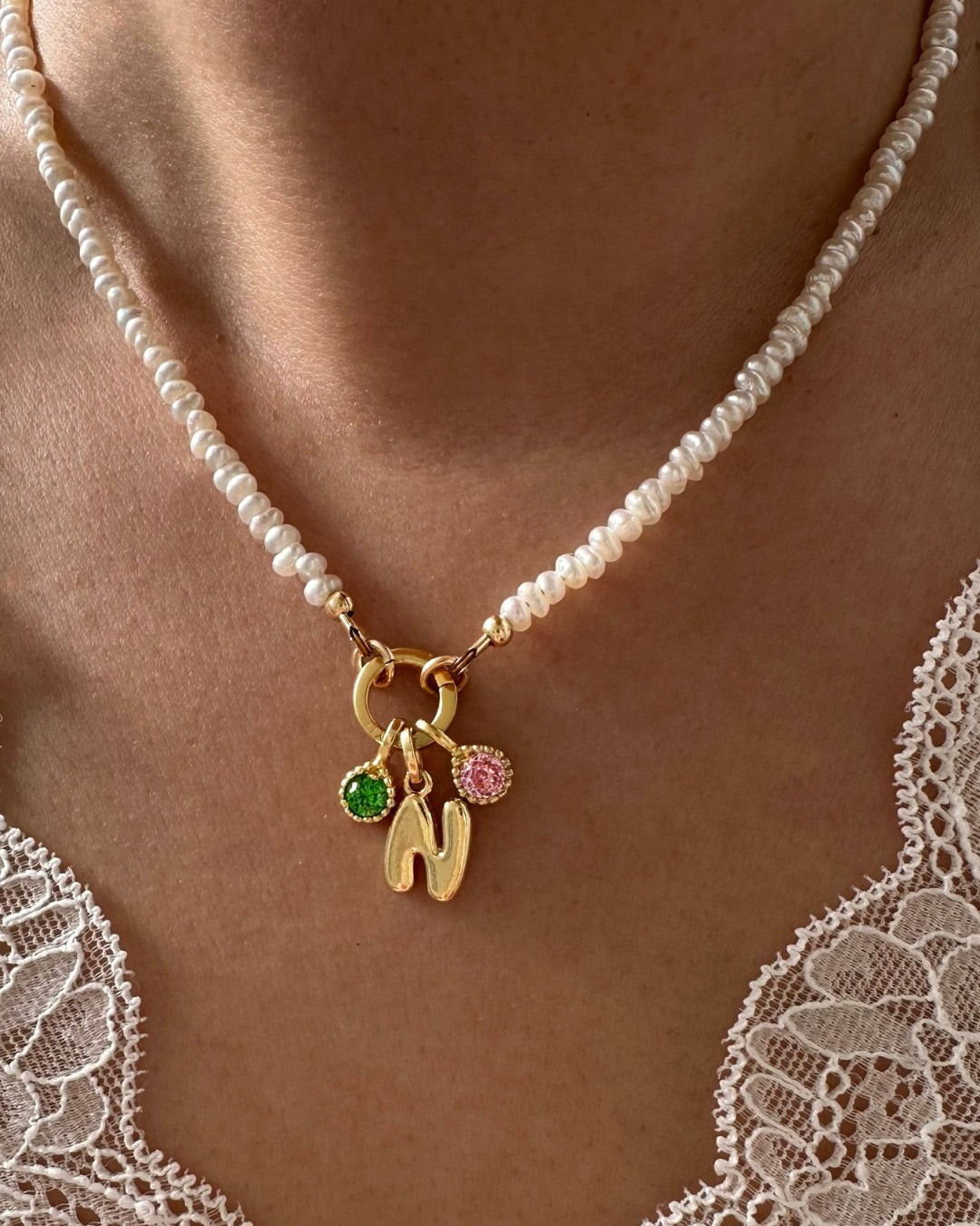 Model wearing Gold Mini Pearl Charm Holder Necklace with Birthstone and Bubble Initial Pendant Charms.