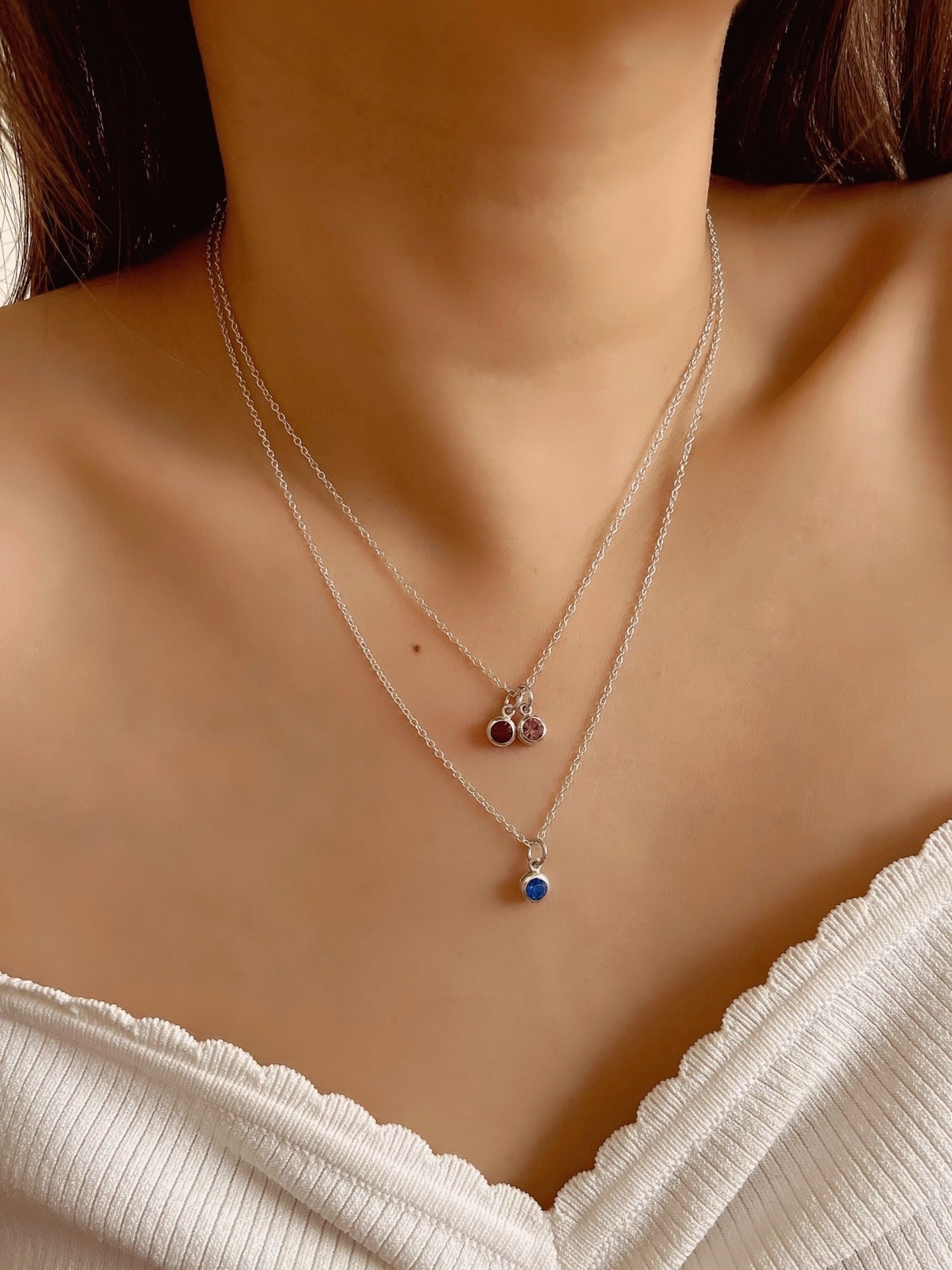 Sterling Silver Birthstone Necklace in May Emerald birthstone, November Citrine birthstone, Pink tourmaline October birthstone and January red garnet birthstone on a model