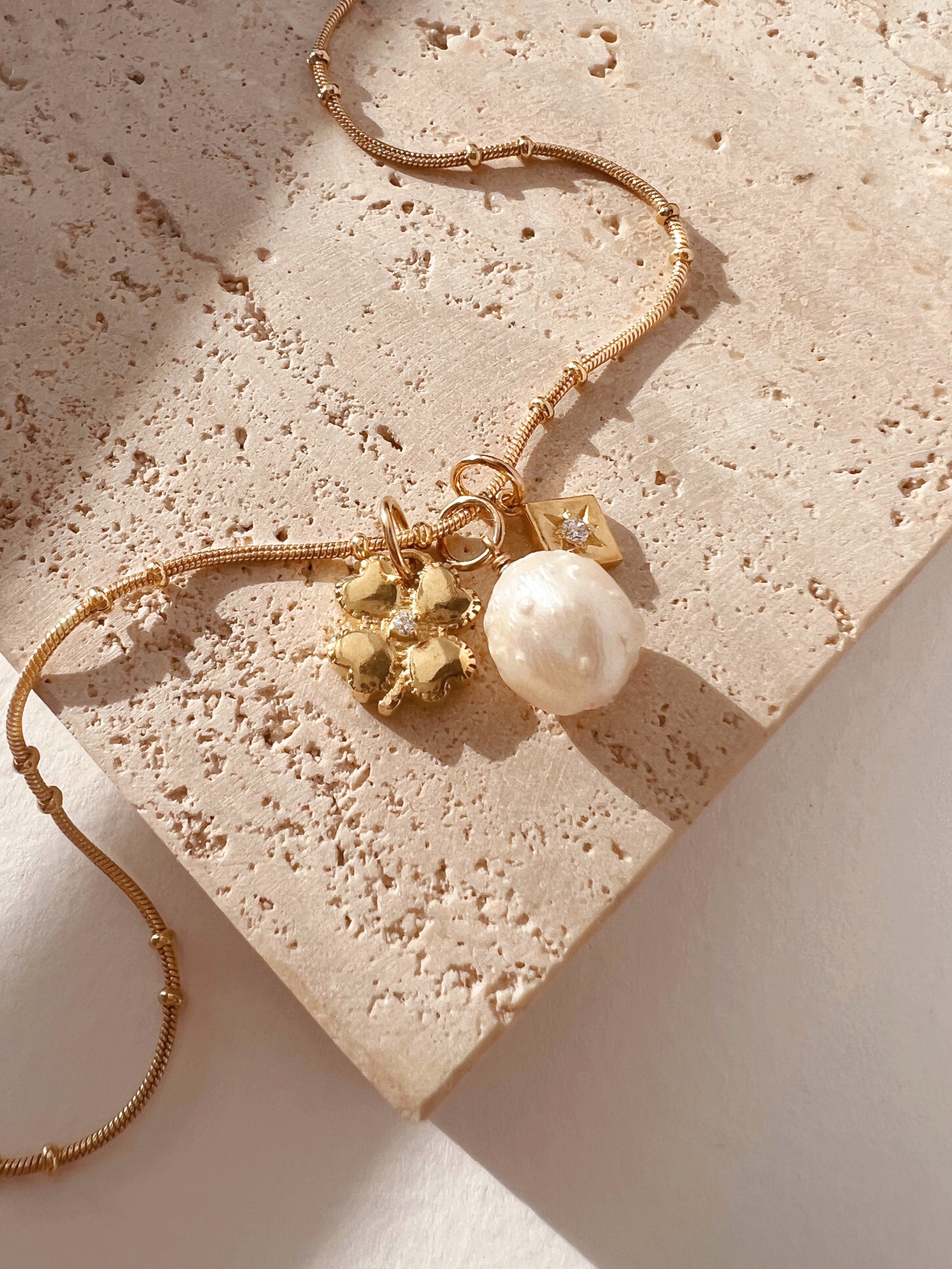 14k yellow gold fill beaded satellite chain necklace with freshwater pearl pendant, gold clover pendant and asteria star small pendant