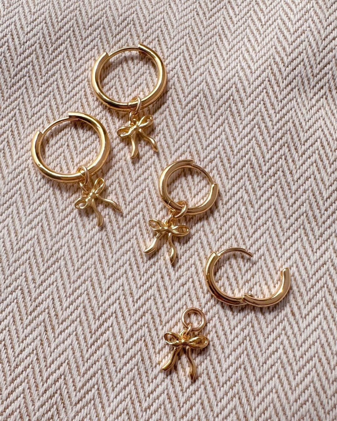 Flatlay of medium and small bow charm hoops