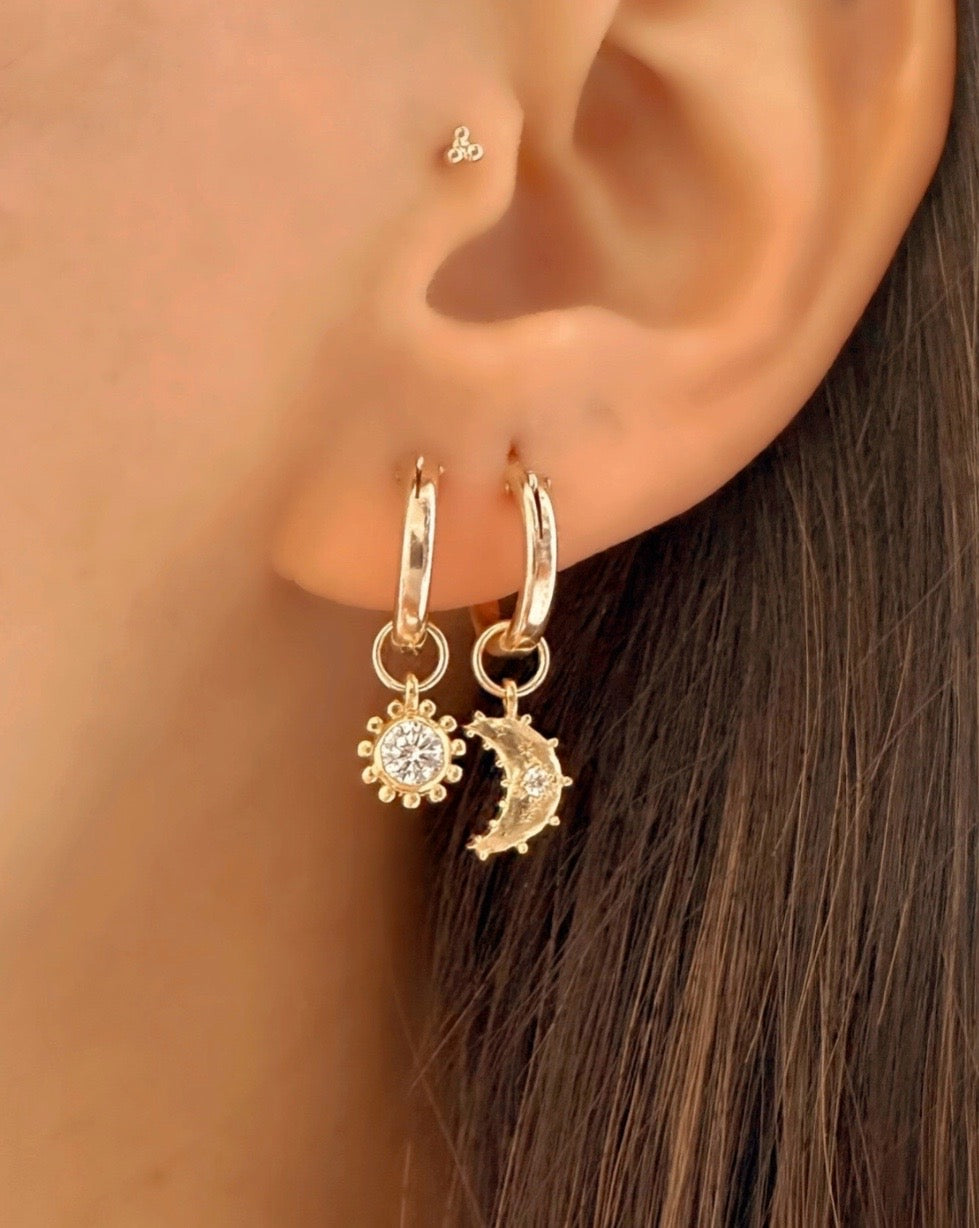 Sola Sun Charm Hoops with removable cubic zirconia sun charm, exclusive Romyli design featuring radiant sunbeam detailing. Sparkling gold hoops for versatile, luminous style.