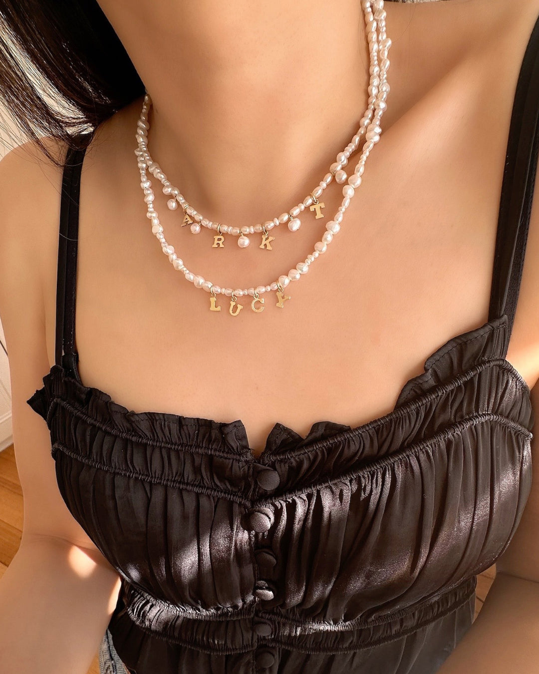 Model wearing 2 layers of Gold-filled Classic Pearl Initial Choker with organic freshwater pearls and customisable initials, puffy heart or mini pearl charms.