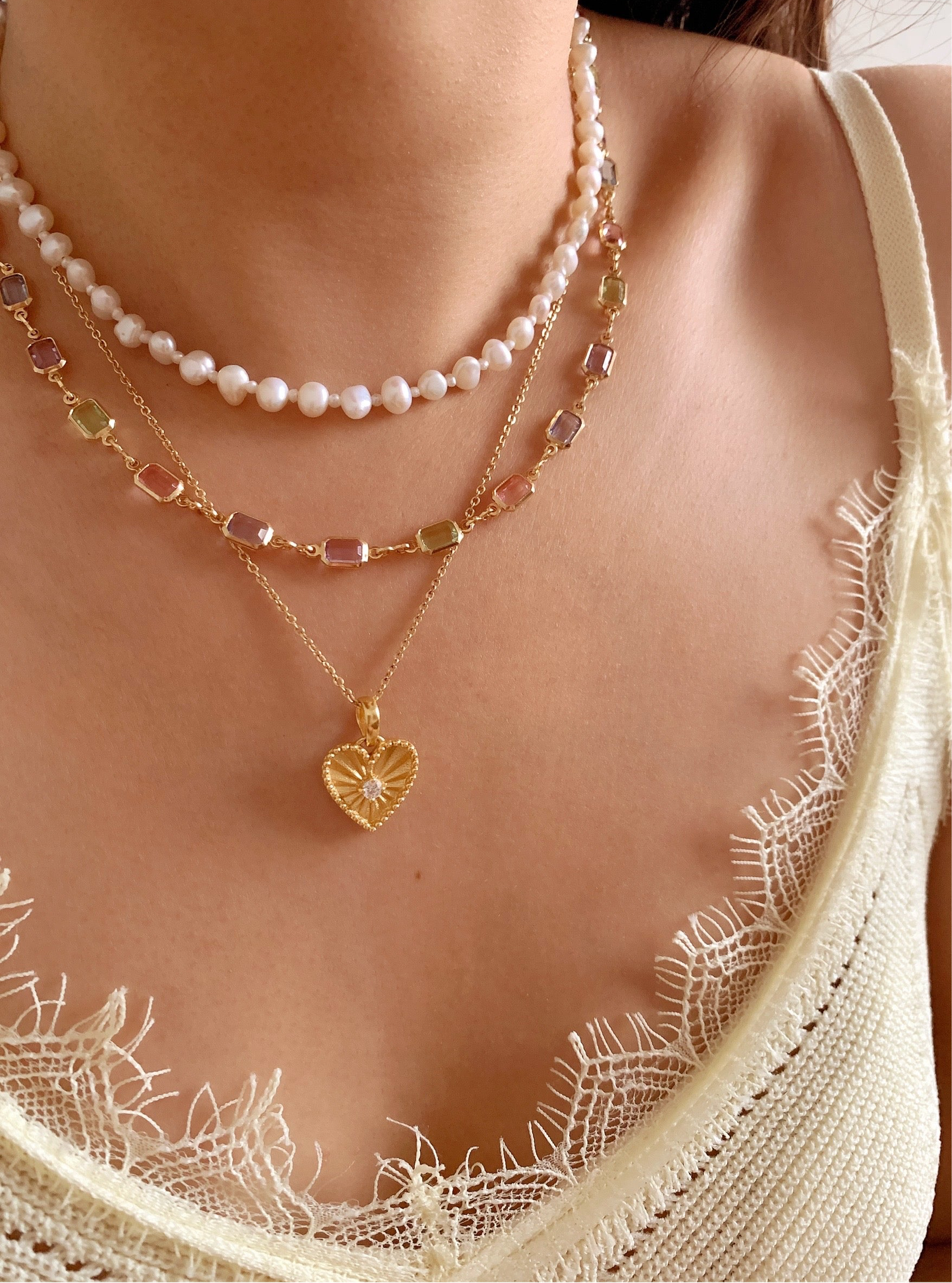 Gold fill necklace in pink, blue and purple bezel gems on a model