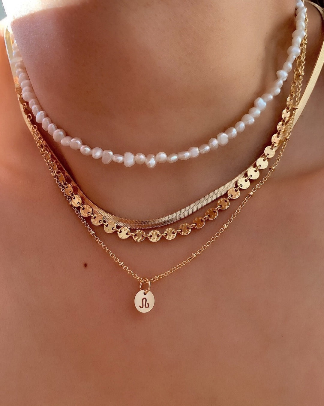Yellow gold fill necklace chain paired with mini zodiac pendant. Layered with the snake chain necklace, pearl choker and molten coin necklace. 