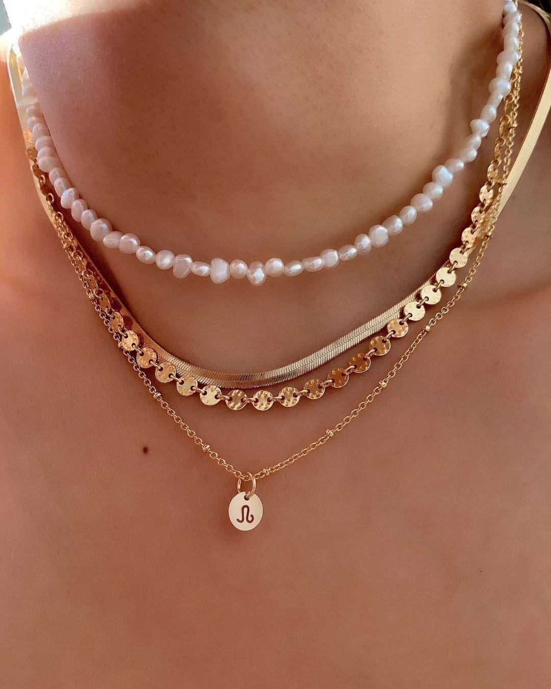 Yellow gold fill necklace chain paired with mini zodiac pendant. Layered with the snake chain necklace, pearl choker and molten coin necklace.