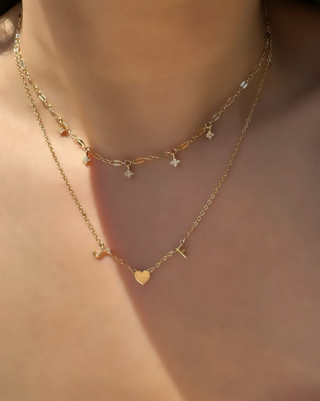 Model wearing Petite Initial Necklace with Gold Heart Charm in the middle, paired with Aurora Star Choker.