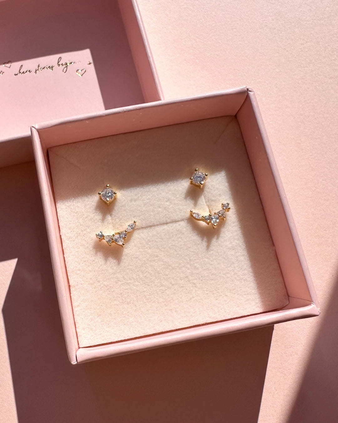 Gold ear jacket earrings with mixed crystal shapes – teardrop, marquise, and round cut sparkle. Flecked Ear Jacket Earrings in a Romyli jewellery box