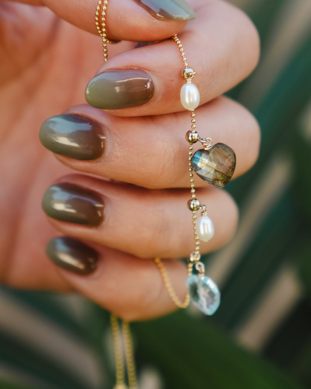 Labradorite heart charm for necklace with blue-green flash, crafted for personalised jewelry. Labradorite gemstone charm adds unique color and meaning.