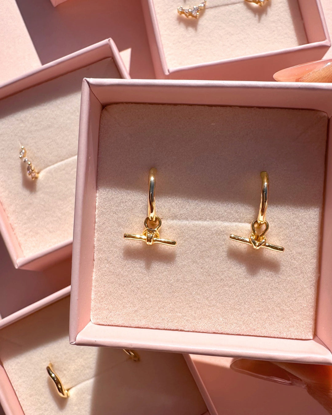 Gold huggie earrings with removable FOB T-bar charm drop in a Romyli jewellery box