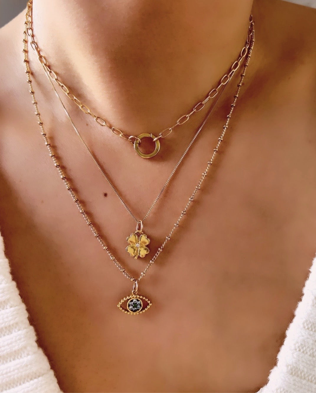Gold fill clover blossom flower talisman protection pendant on a gold necklace chain on a model