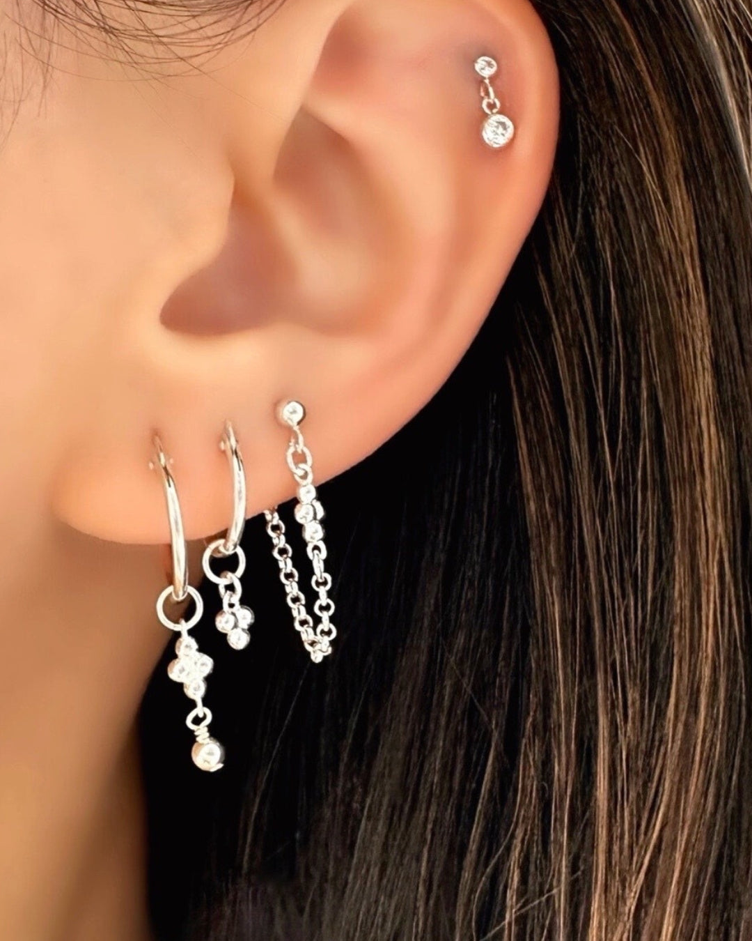 Sterling silver mini spheres trinity ball satellite hoops Huggies and chain stud earrings set on a model