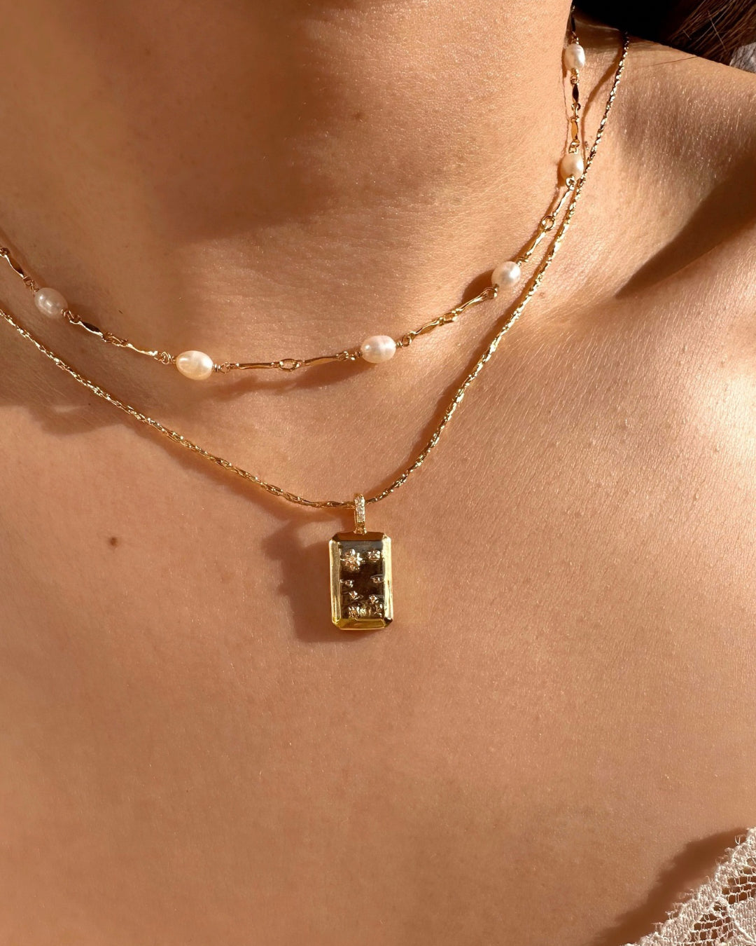 Gold Gemini Constellation Zodiac Necklace and Gold Opalene Pearl Choker Necklace on a model