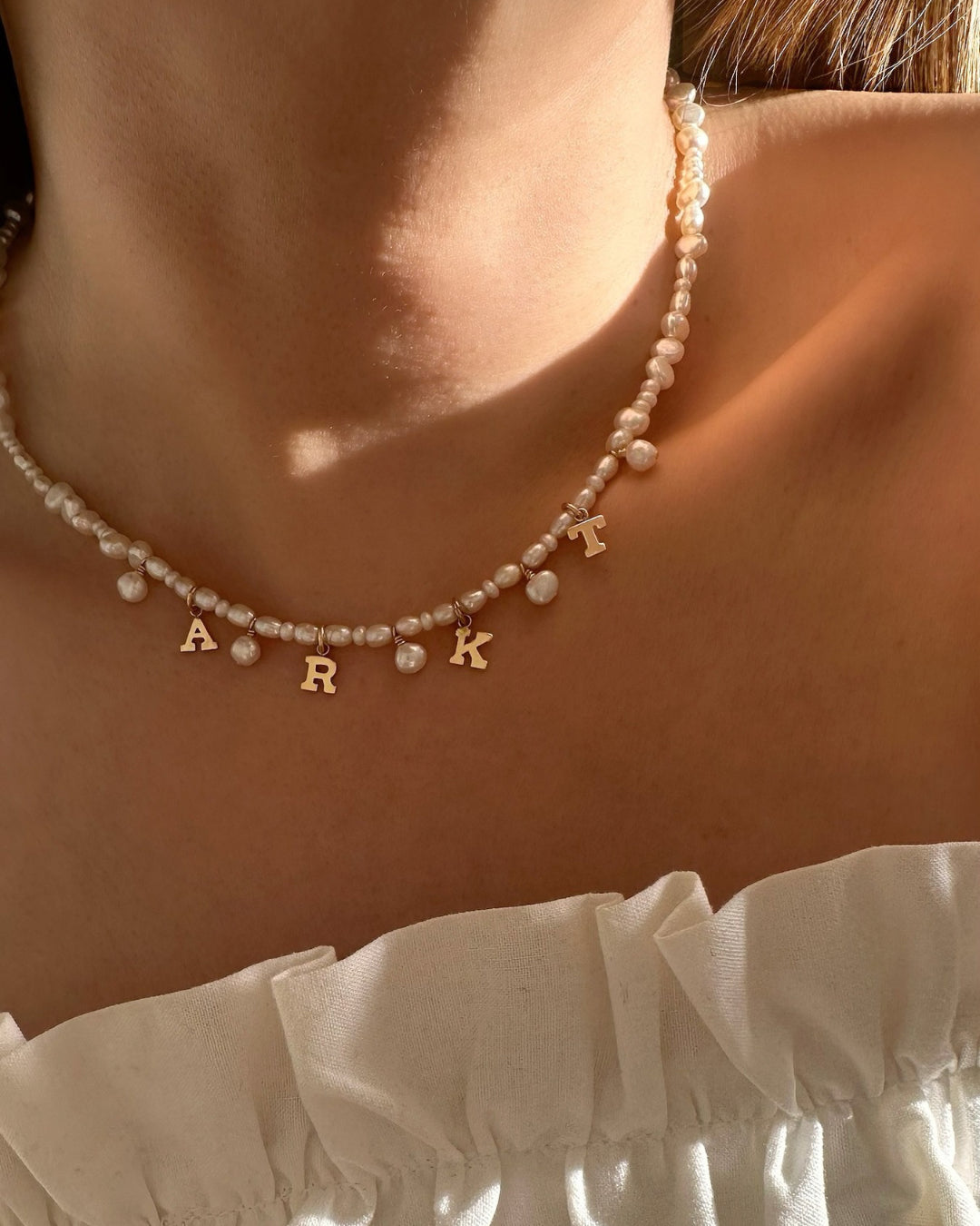 Model wearing Gold-filled Classic Pearl Initial Choker with organic freshwater pearls and customisable initials and mini pearl charms.