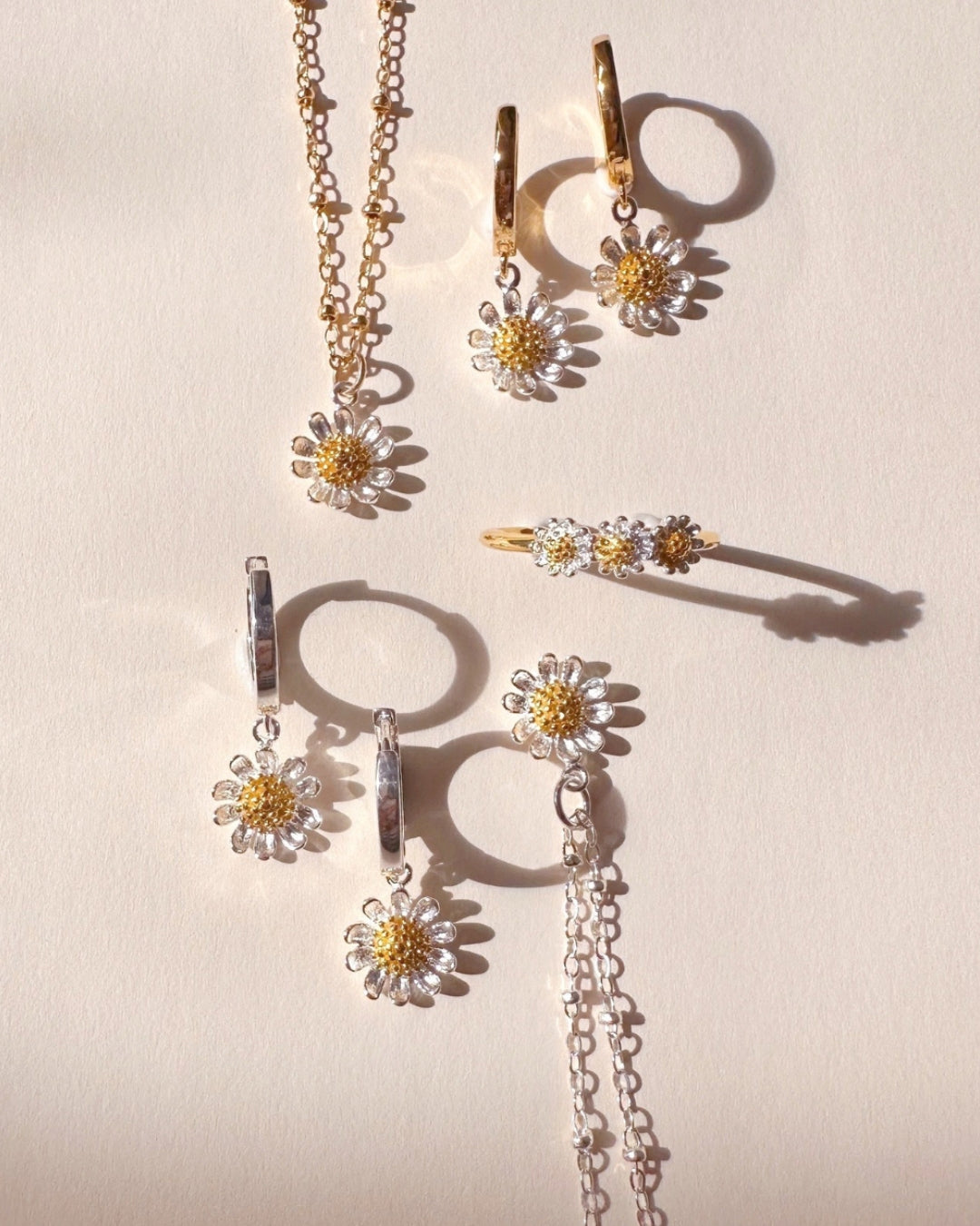 Daisy Bloom jewellery collection by Romyli, featuring dainty gold and silver necklaces, hoops, and ring with two-tone daisy motifs.