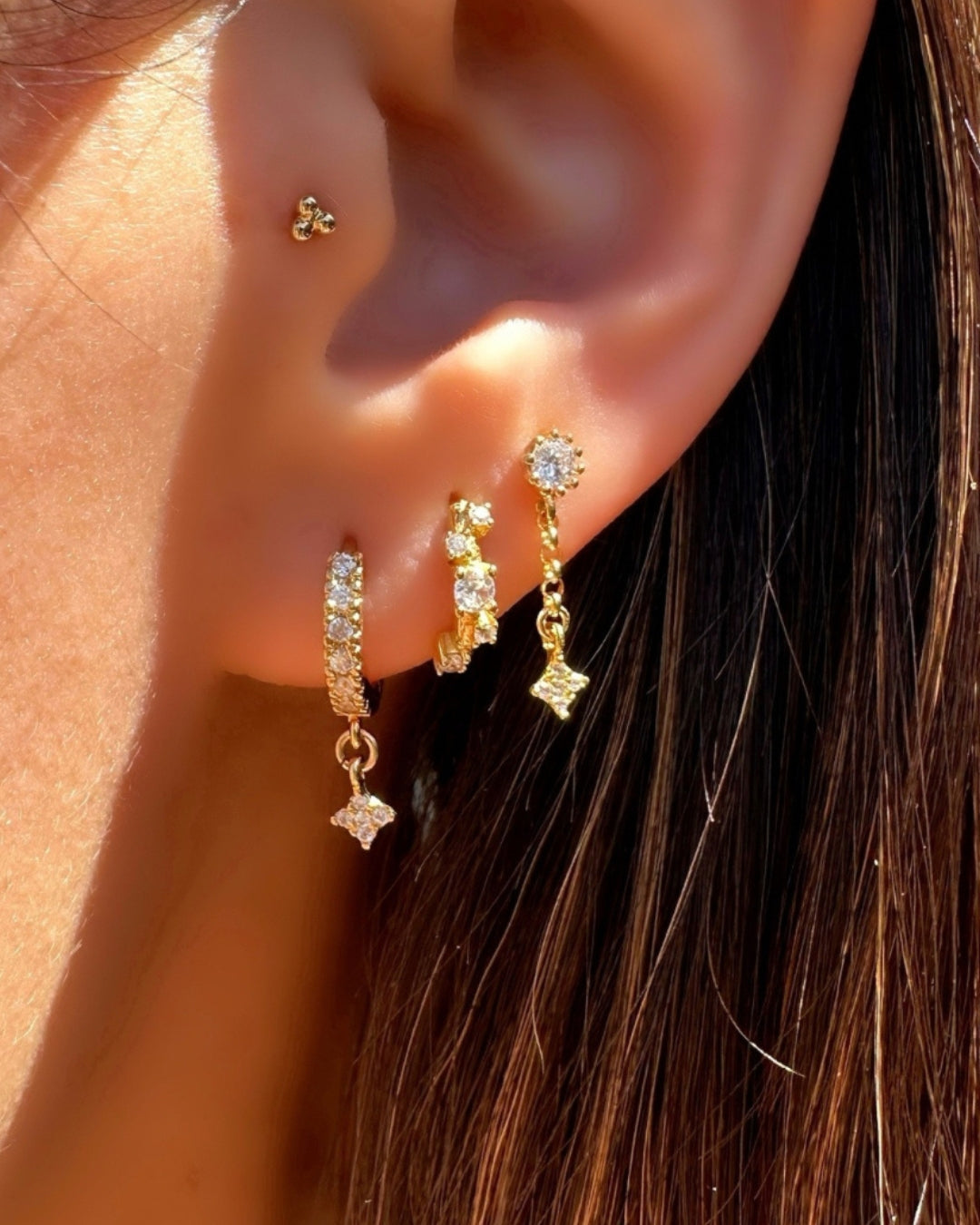 Model wearing dainty Stellar Cluster Huggies with alternating organic crystal design along the front.