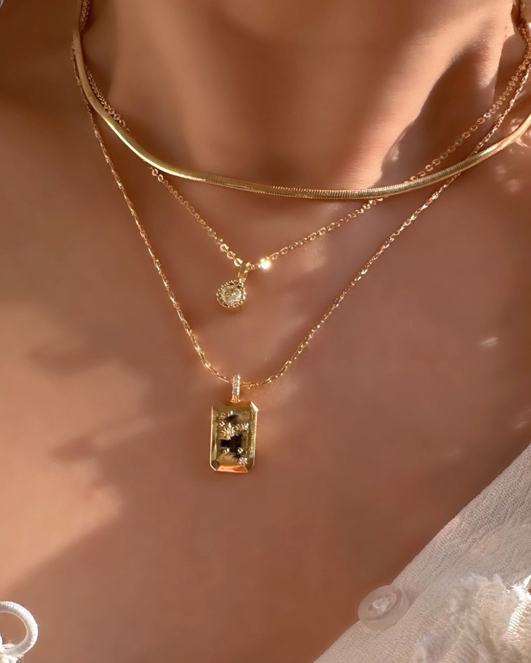 Model wearing Gold August Birthstone Necklace, Leo Constellation Necklace and Petite Snake Chain Chokerz
