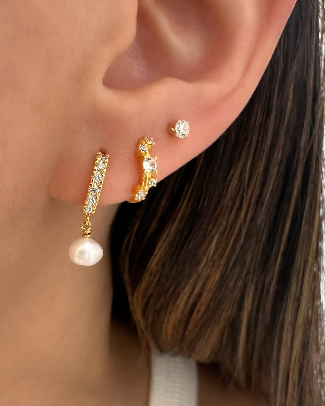 Model wearing gold pavé huggie hoop earrings with organic freshwater pearl drop – gold vermeil huggies set with cubic zirconia and baroque pearl charm