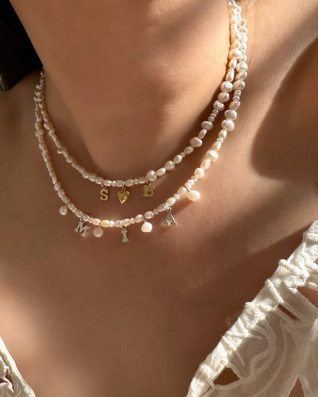 Model wearing Gold and Sterling silver Classic Pearl Initial Choker with organic freshwater pearls and customisable initials, puffy heart or mini pearl charms.