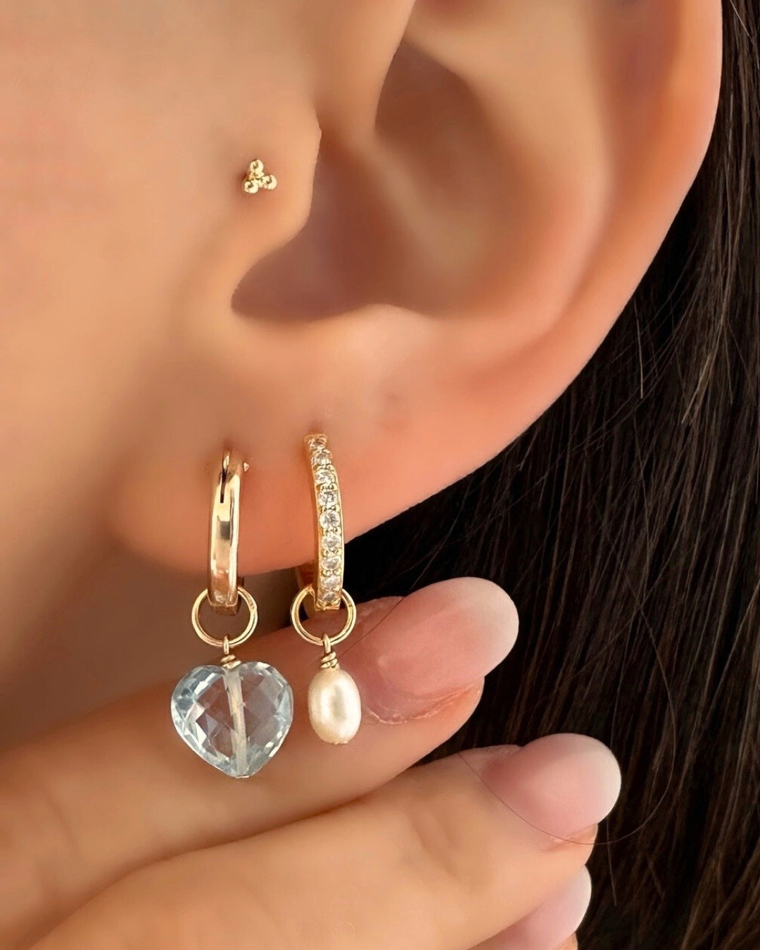 Close-up of a genuine topaz heart earring charm in 14k gold fill, approximately 10mm in size, designed for mix-and-match styling. Light blue gemstone symbolising clarity, strength, and joy, compatible with all hoops in the Mix and Match Earrings collection.