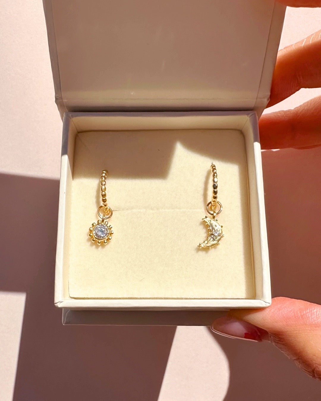 Close-up of the Sola sun earring charm in 14k gold fill, approximately 8mm in size, designed to fit all hoops in the Mix and Match Earrings collection. Sun design symbolising energy, vitality, and growth.