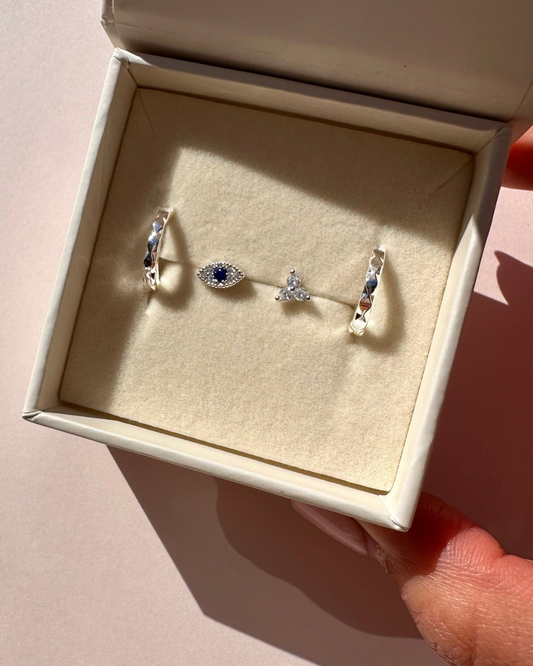 Sterling silver huggie hoop earrings with a hammered finish and no charms, displayed in a ROMYLI gift box