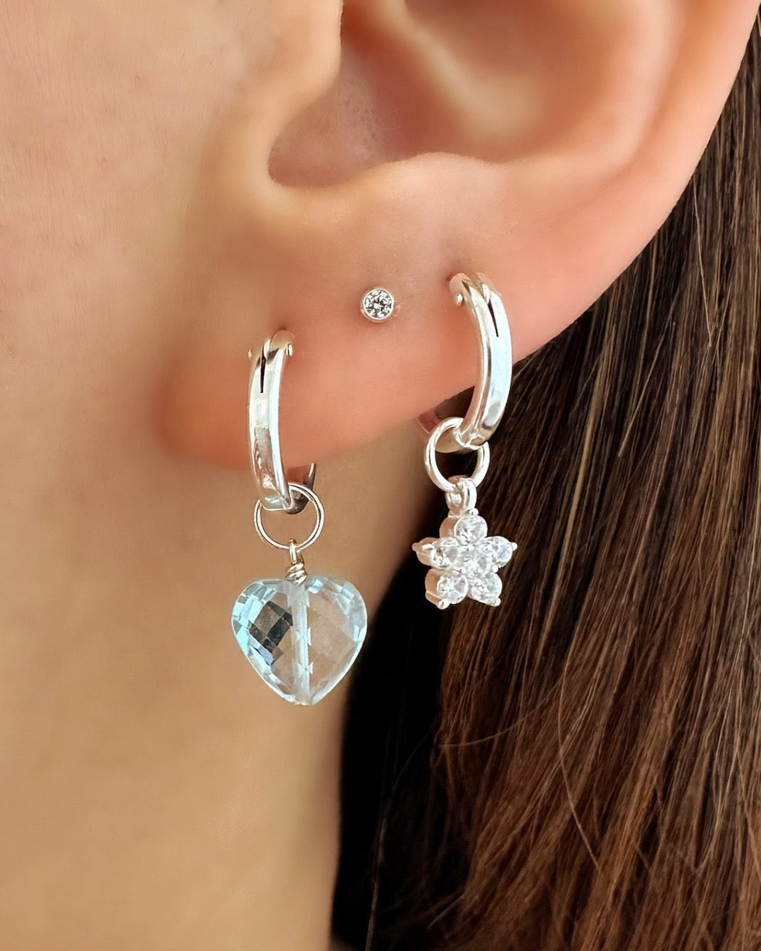 Model wearing Sterling silver Mini Euro Hoops paired with Blue Topaz Heart Charm and Flora Earring charm