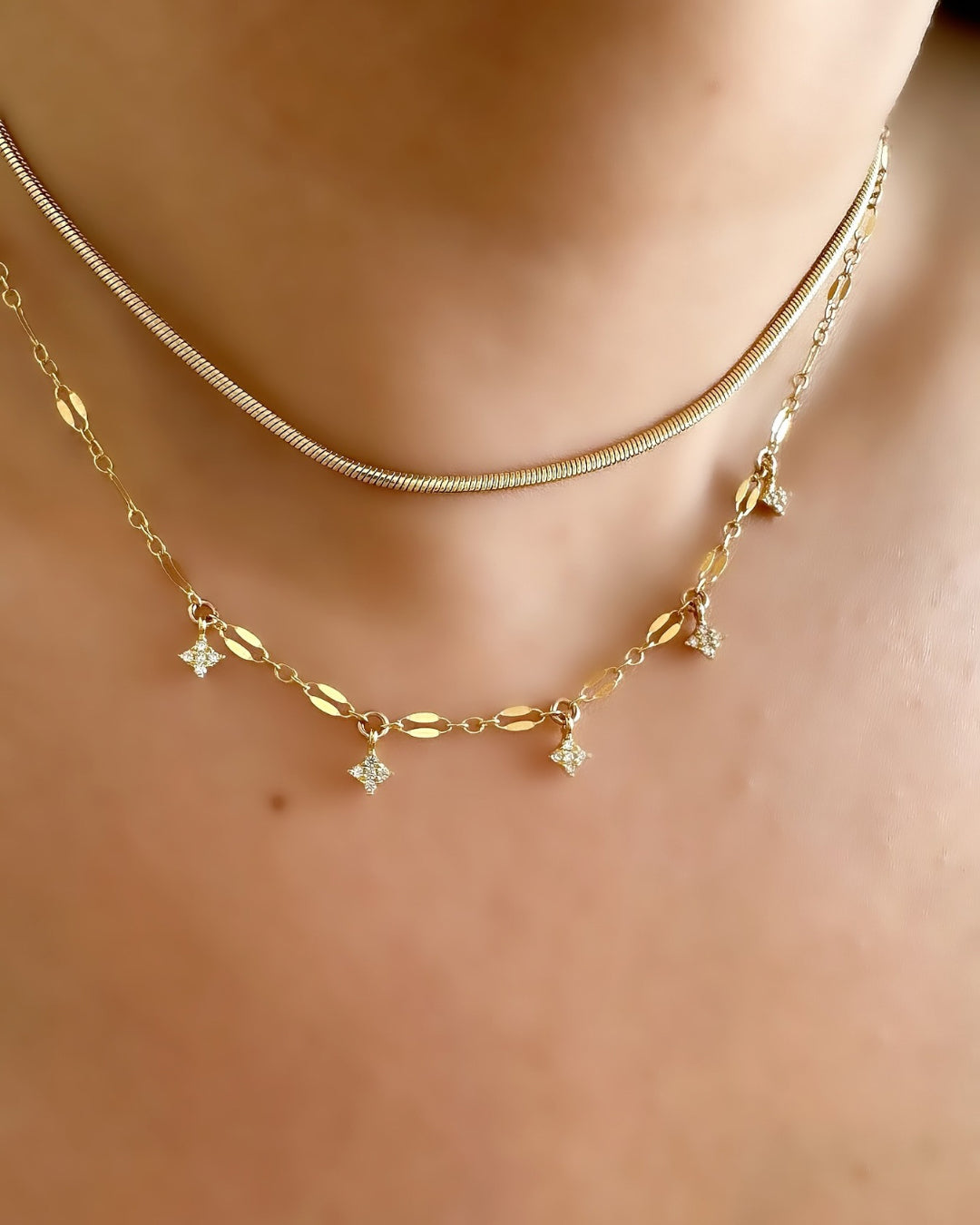 Choker length Aurora Star Necklace with light-reflecting chain and tiny crystal North Star charms on a model.