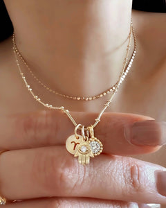Gold beaded necklace chain in yellow gold paired with the mini zodiac, hamsa and birthstone pendant. 