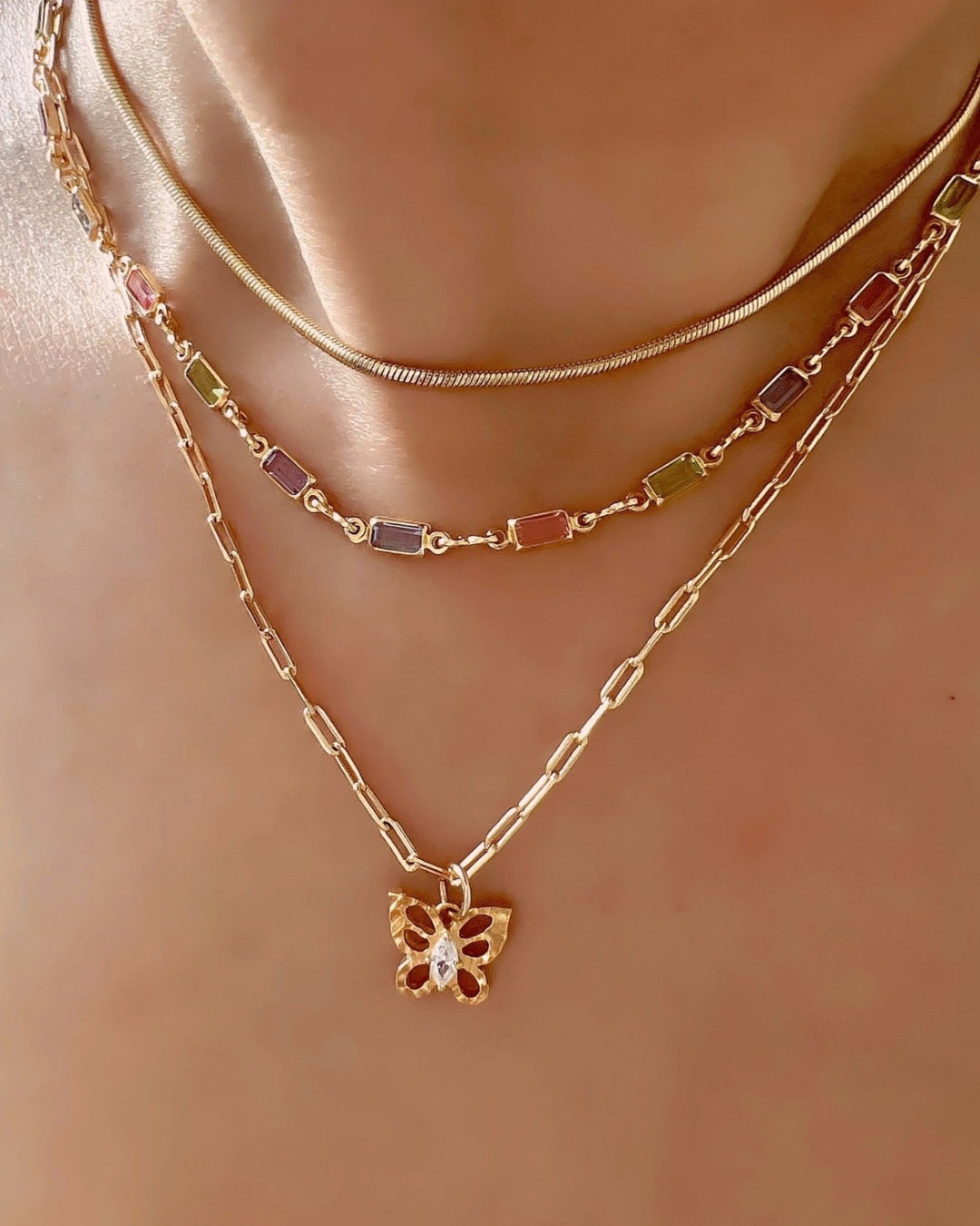 Yellow gold filled paperclip chain necklace paired with the textured butterfly pendant. Layered with the pastel coloured capri necklace and gold snake chain necklace.