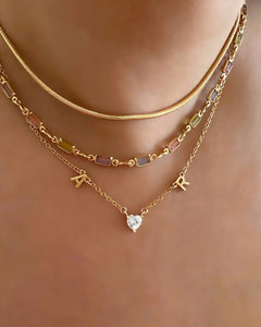 Gold Petite Initial Necklace with Letter A, Heart Gem, Letter R on a model 