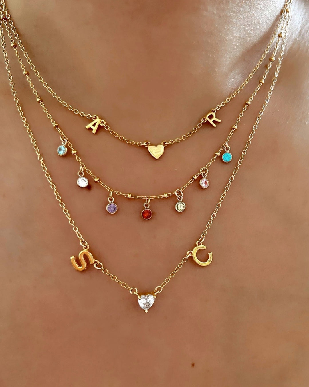 Gold Petite Initial Necklace layered with Gold Petite Birthstone Necklace and Gold Initial Necklace on a model