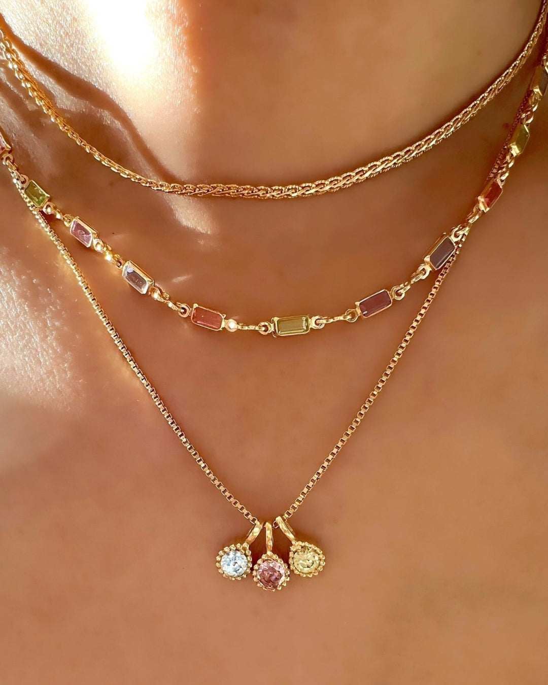 Gold Birthstone Necklace in Colours and Months, including January Garnet, February Amethyst, March Aquamarine, April Diamond, May Emerald, June Alexandrite, July Ruby, August Peridot, September Sapphire, October Tourmaline, November Citrine and December Topaz Cubic Zirconia Crystals on a model
