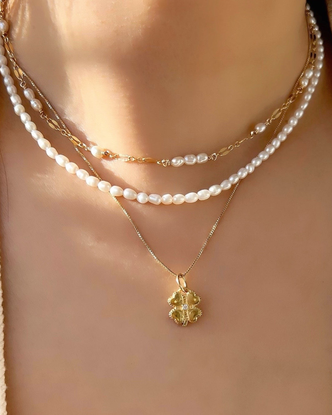Gold fill clover blossom flower talisman protection pendant on a gold necklace chain on a model
