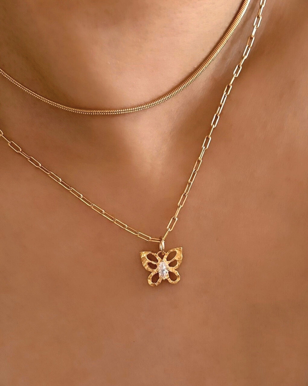 14k gold fill textured butterfly talisman protection pendant on gold paperclip necklace chain with sparkly crystal centre on a model