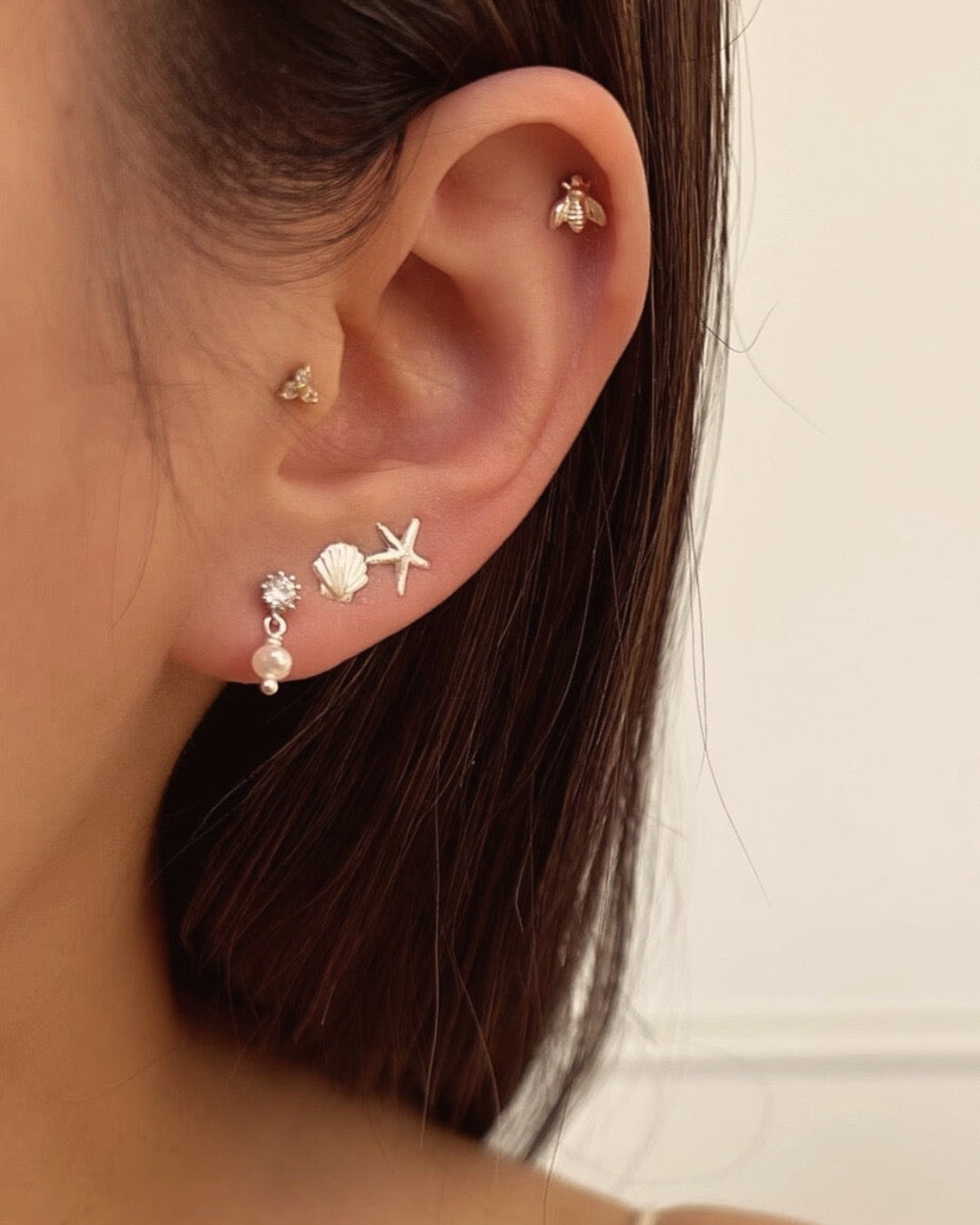 Sterling silver starfish stud post earrings with butterfly backs on a model