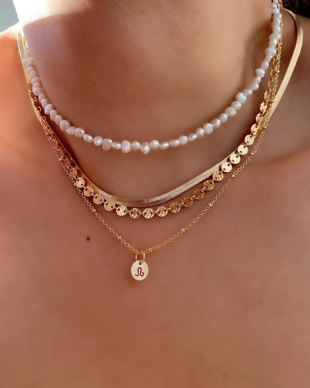 14k gold fill small zodiac sign coin pendant charms with a satellite chain necklace on a model