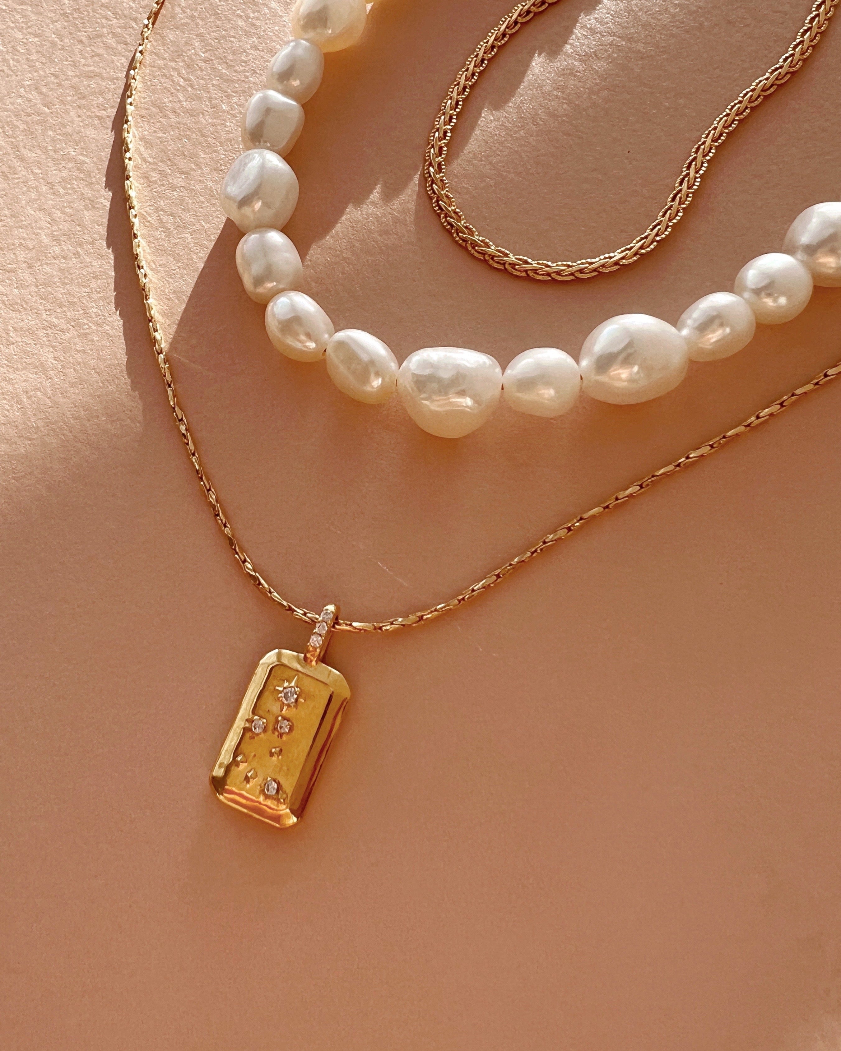 Gold Capricorn Constellation Zodiac Pendant on a Gold Necklace Chain with the Baroque Pearl Necklace