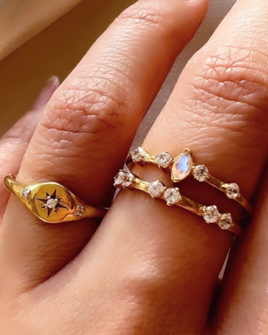 14k gold fill Star signet ring with crystal encrusted North Star centre flanked with 2 micro pave cubic zirconia crystals on shoulder of ring on a model.