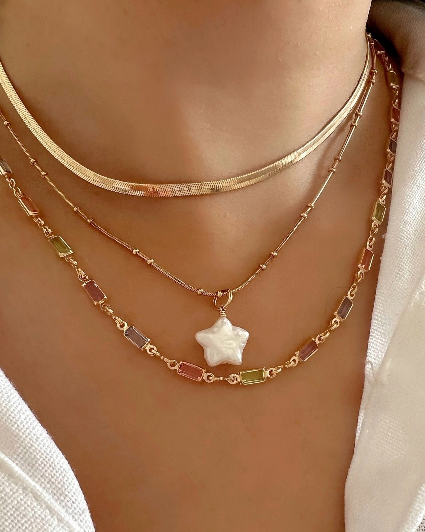 14k gold fill freshwater pearl star pendant charm with a gold satellite chain on a model