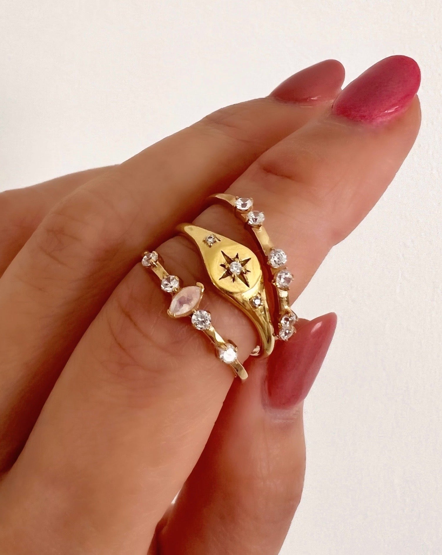 14k gold fill Star signet ring with crystal encrusted North Star centre flanked with 2 micro pave cubic zirconia crystals on shoulder of ring on a model.
