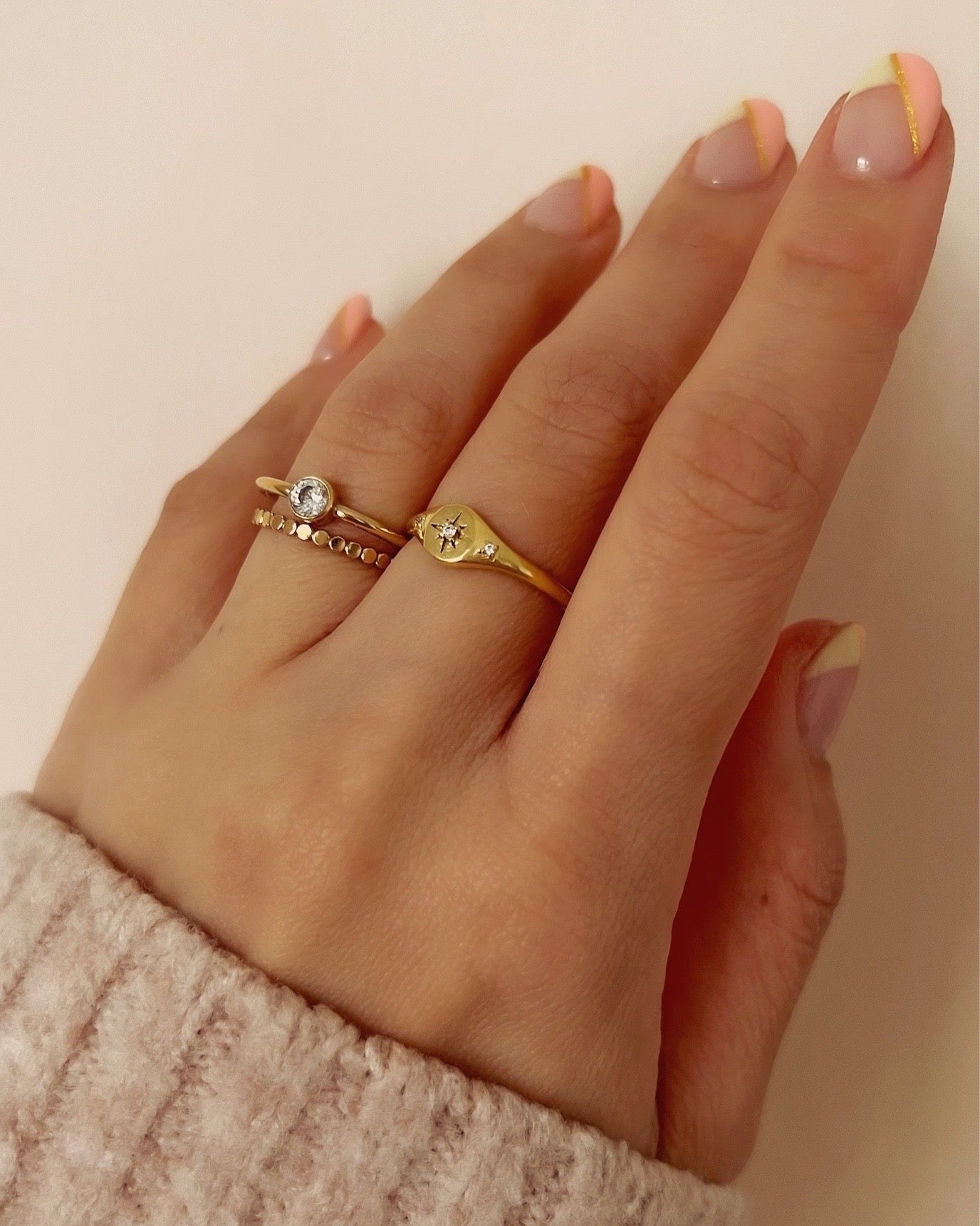 14k gold fill Star signet ring with crystal encrusted North Star centre flanked with 2 micro pave cubic zirconia crystals on shoulder of ring on a model.