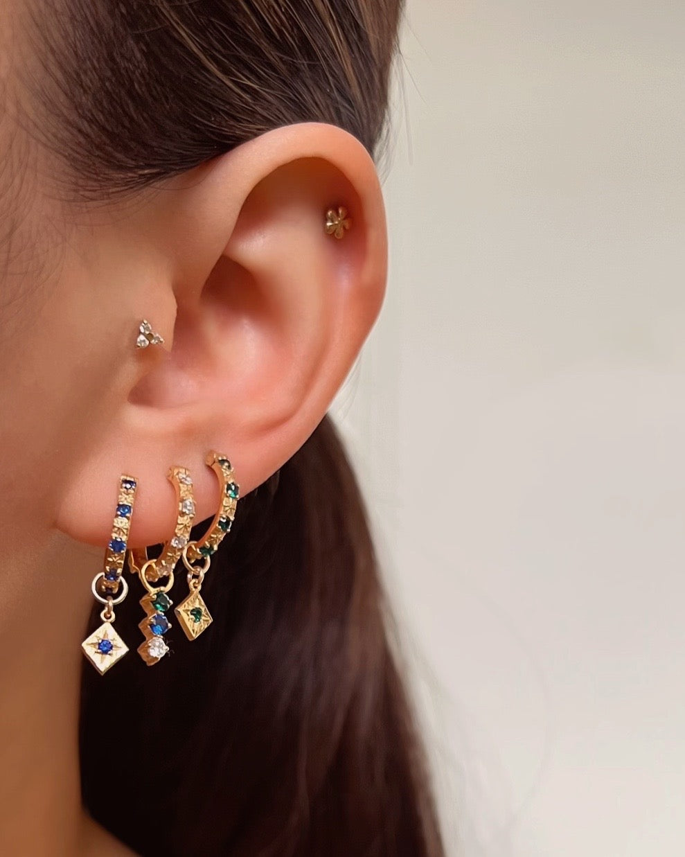 14k gold fill earring charm for hoops in emerald green, sapphire blue and white diamond cubic zirconia with Asteria sapphire hoops on a model