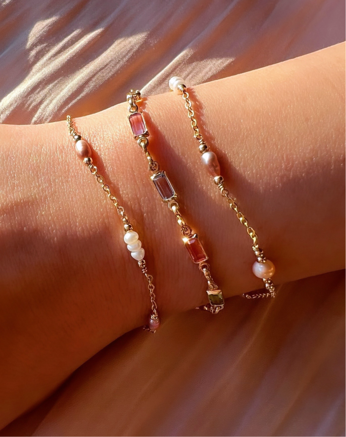 Gold fill bracelet in pink, blue and purple bezel gems on a model 