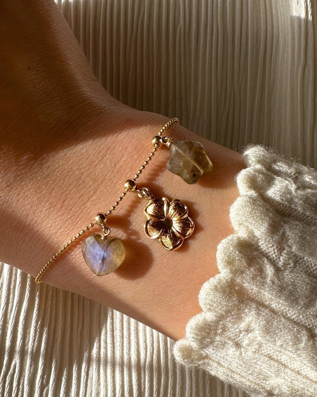 Model wearing 14k gold fill posy charm on a Charm Story Bead Bracelet