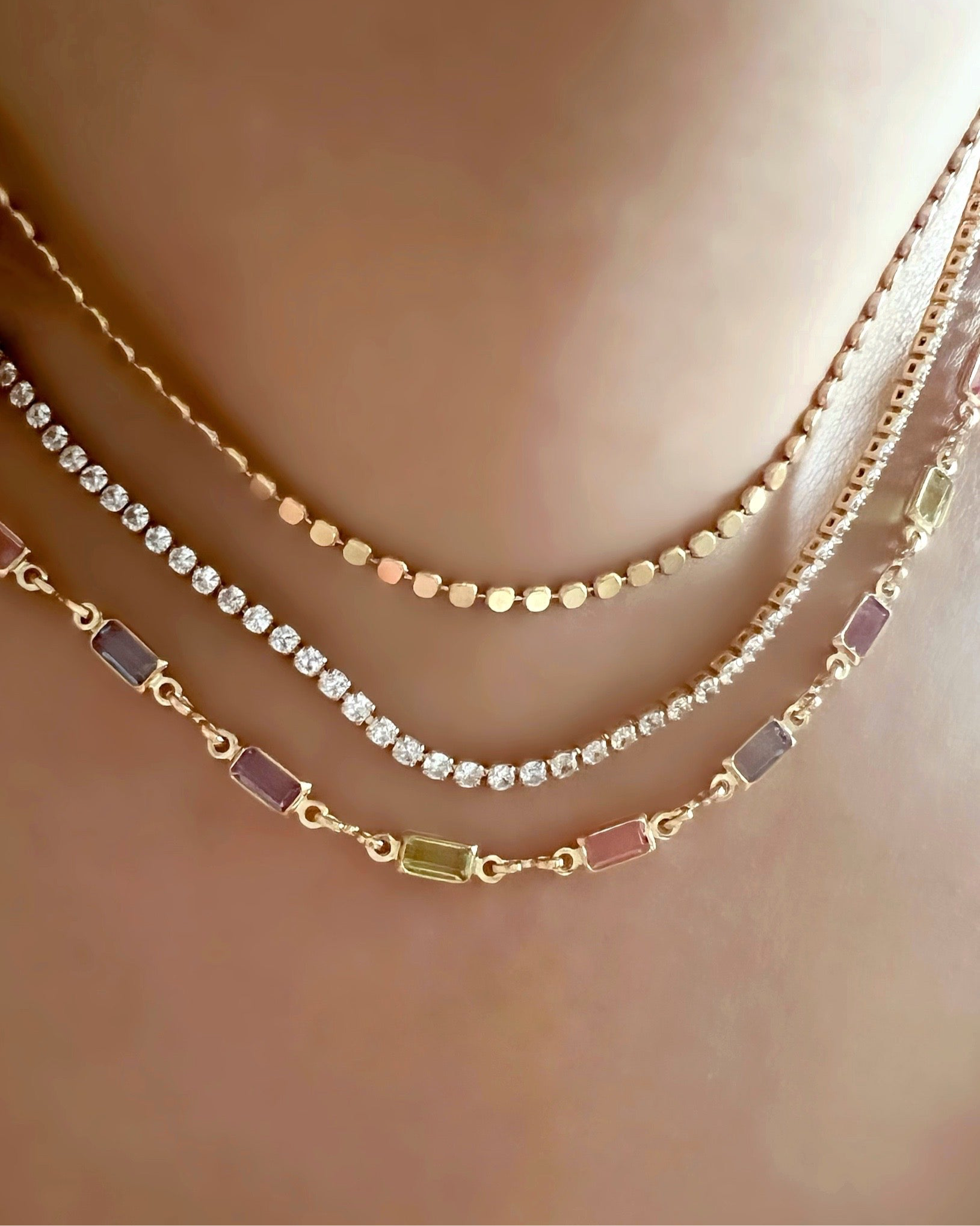 Petite Gold fill necklace in pink, blue and purple bezel gems on a model 