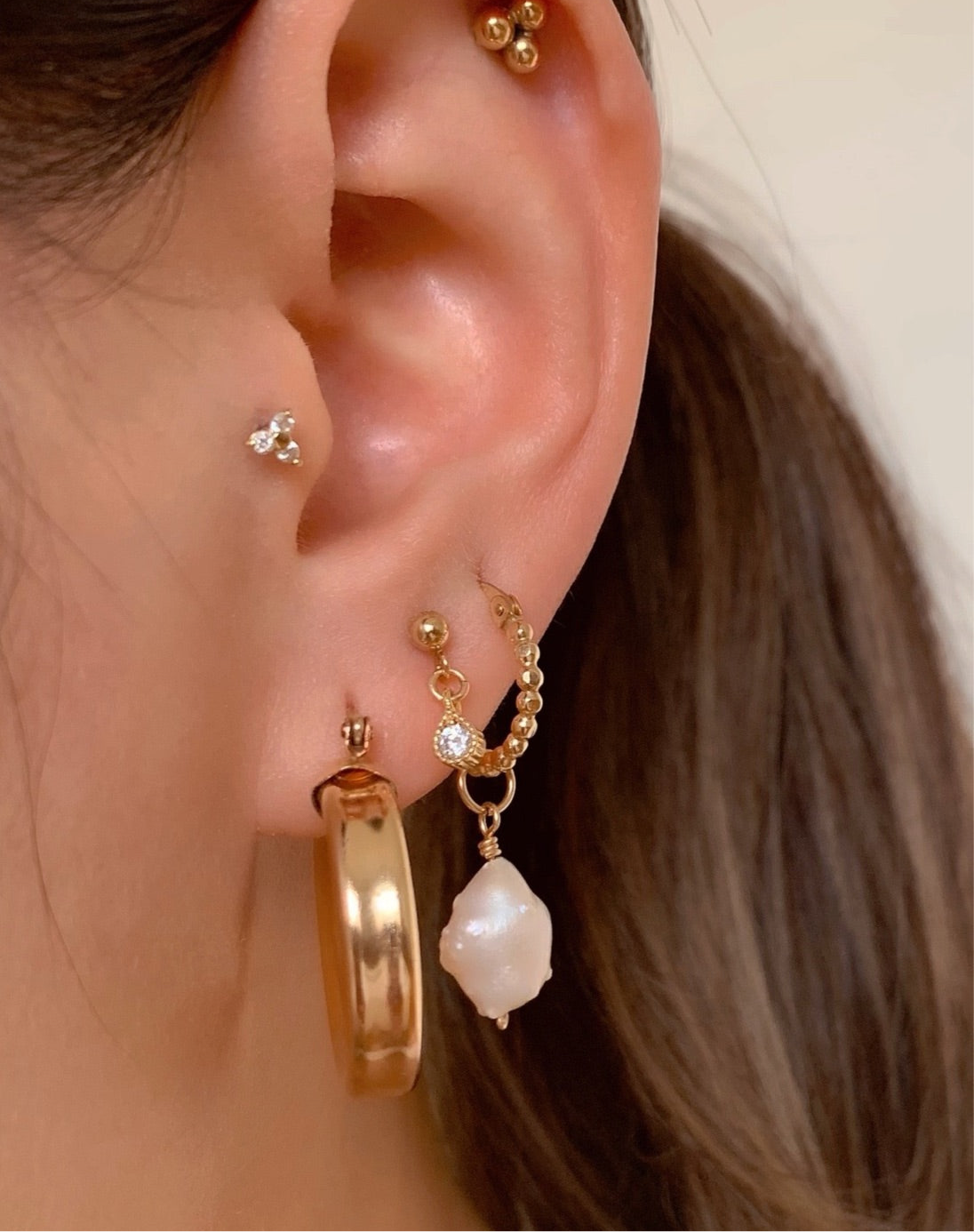 14k yellow gold fill chunky bold hoops earrings on a model 