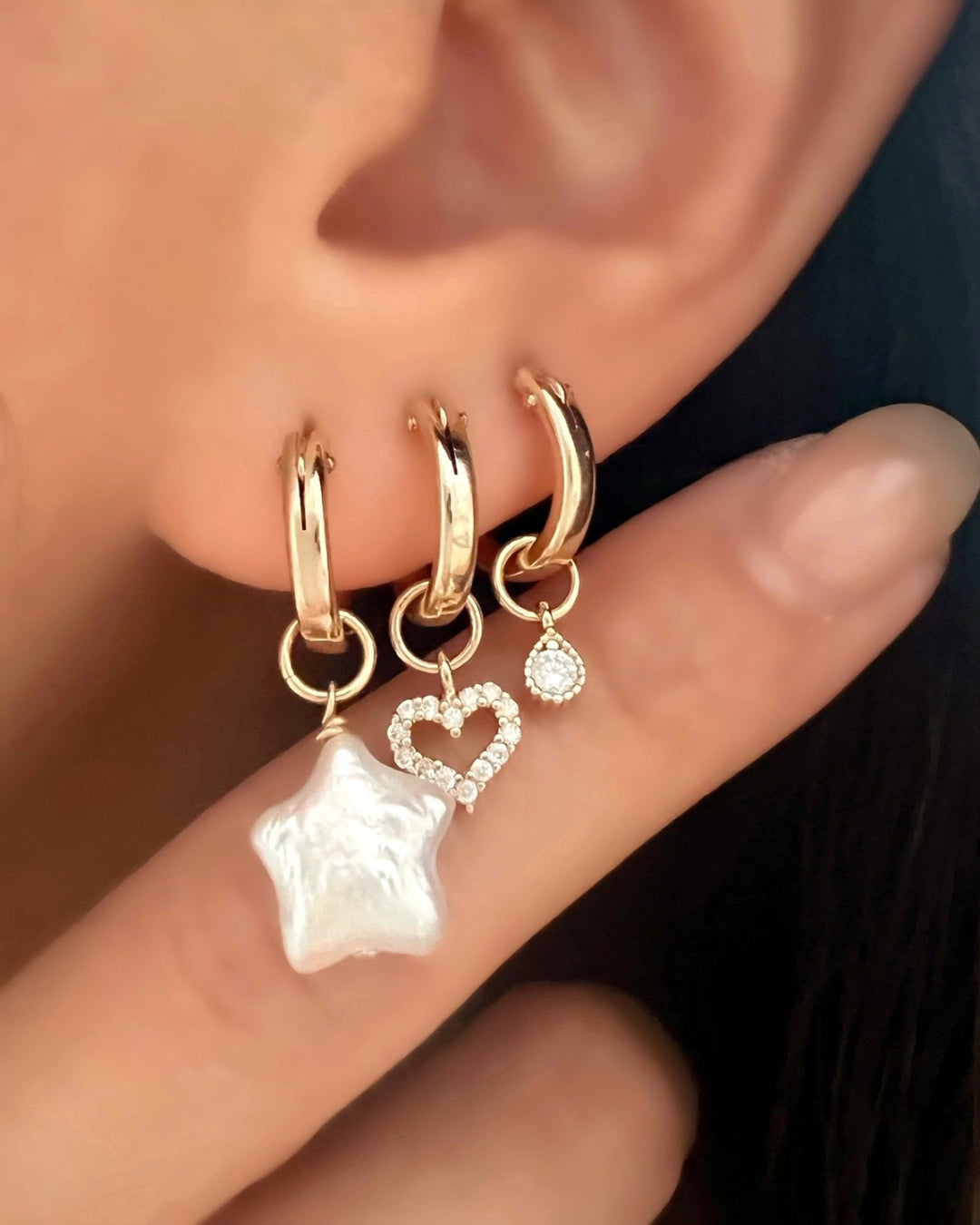 Gold pave heart charm hoops earrings layered with freshwater pearl star hoop earrings and gold fill teardrop hoop earrings 