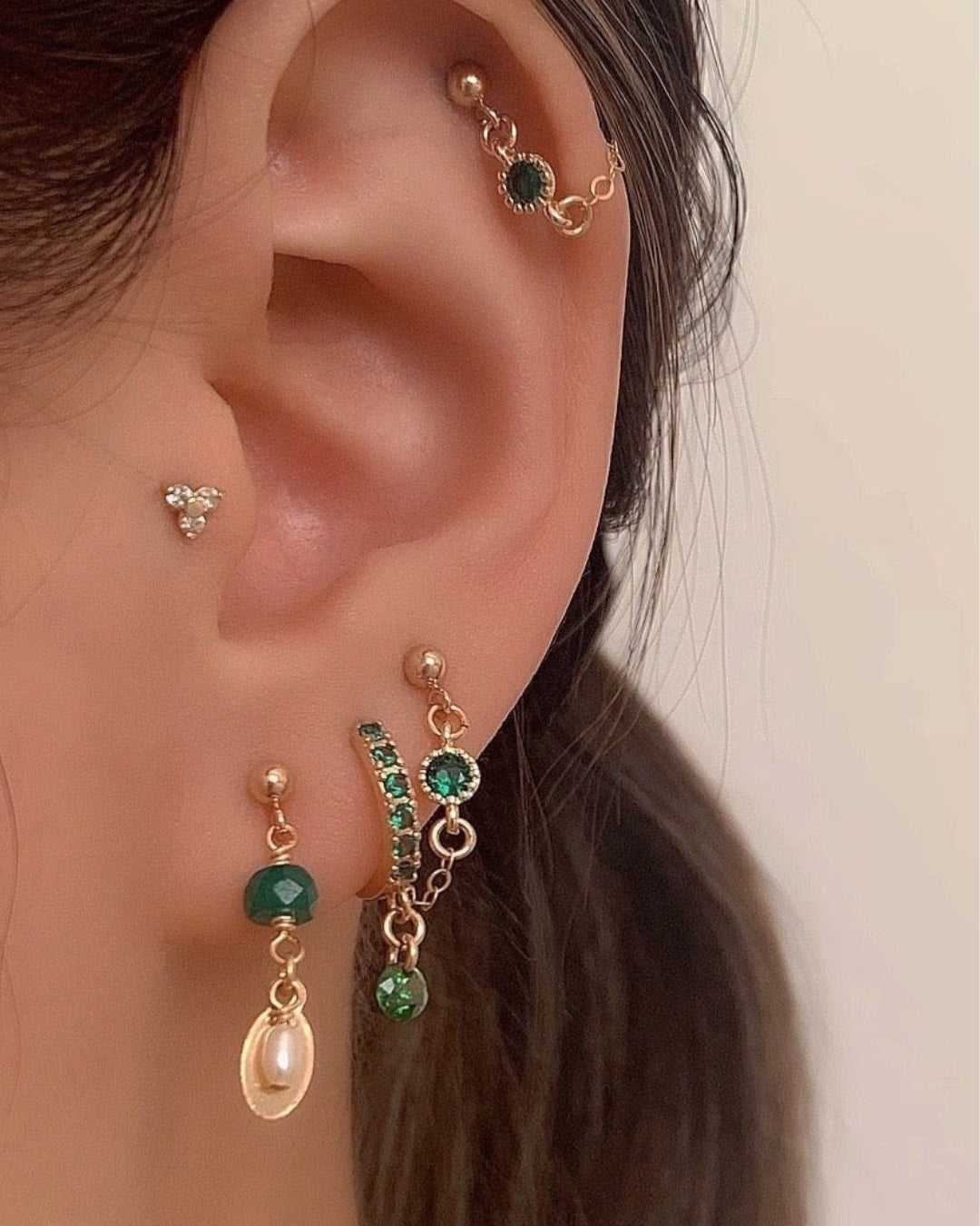 14k gold fill envy chain studs earrings in green emerald cubic zirconia crystal on a model 